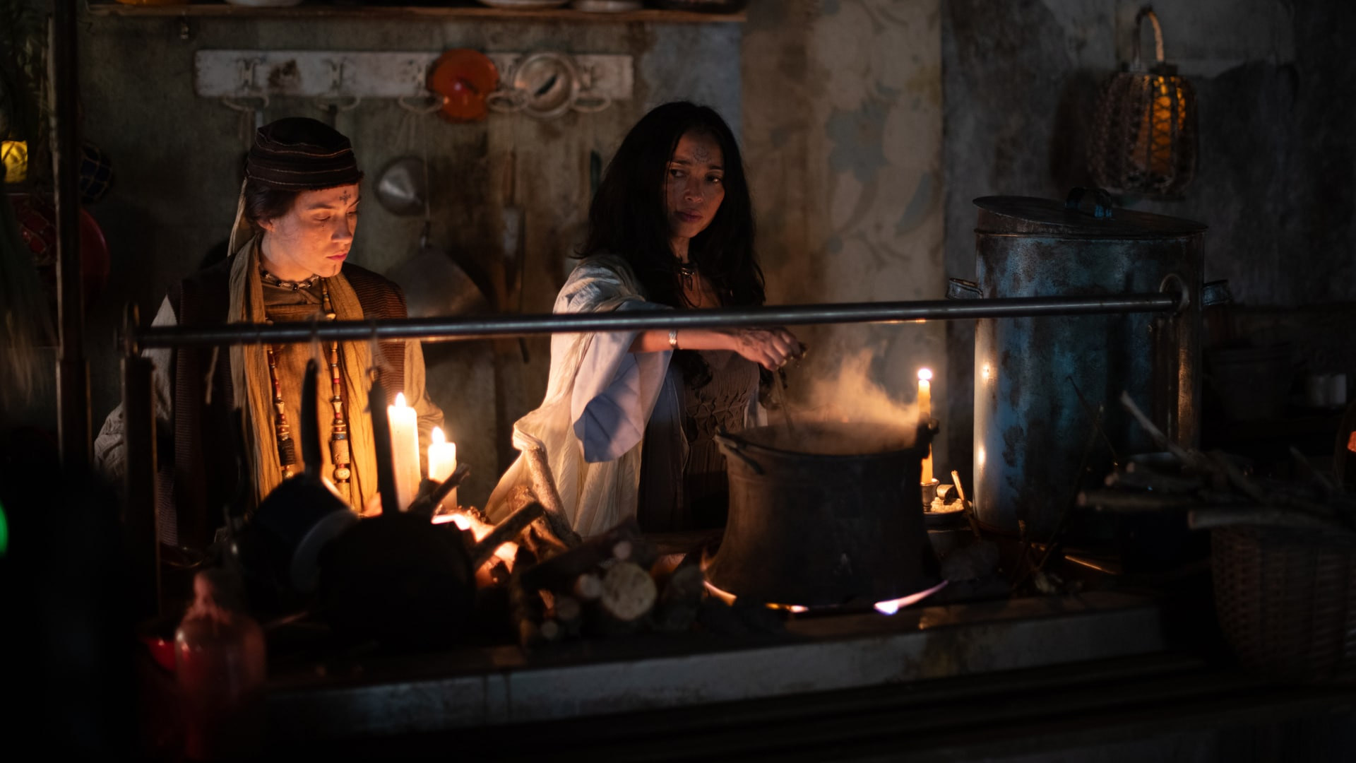 Fotogramma di Milarepa: due ragazze accanto a un focolare, alla luce delle candele